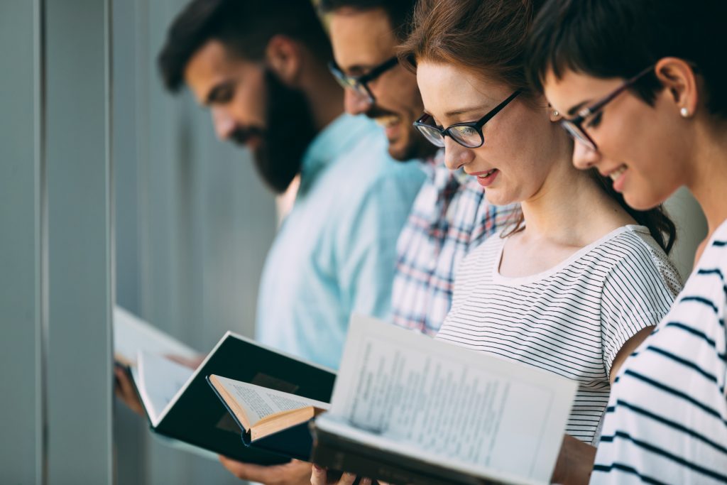 Group of college students studying at library